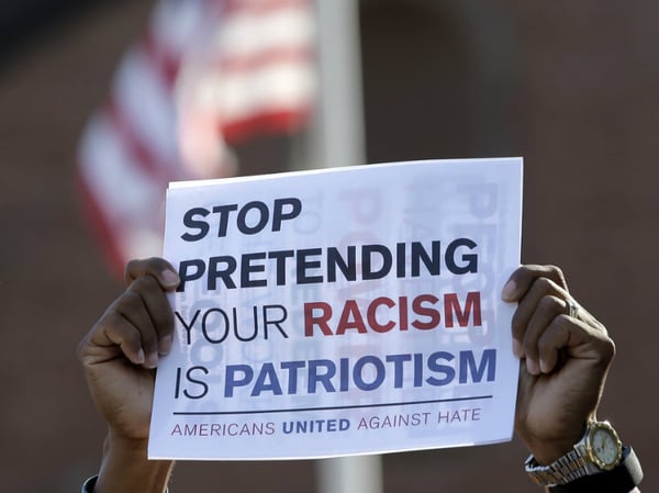 David Brown, of Plymouth, Mass., holds a placard during a protest Sunday in Plymouth. The protest was held to denounce hatred and racism in response to a nationalist rally that spiraled into deadly violence in Charlottesville, Va., on Saturday.